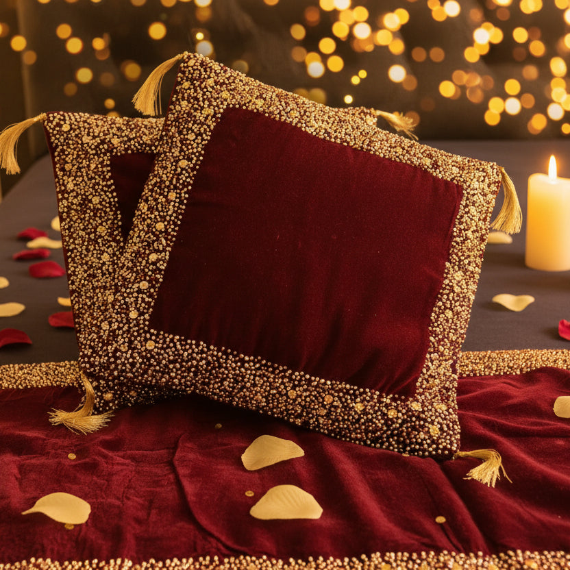 Maroon velvet pillow with gold embroidery on a matching fabric background
