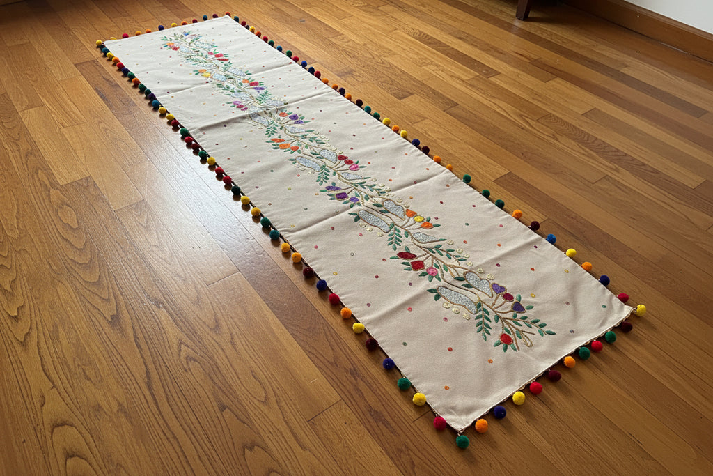 Decorative fabric with embroidery and colorful pom-poms on a dark background