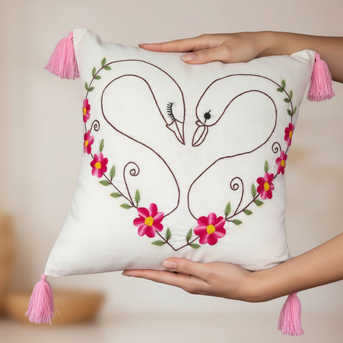 Decorative pillow with embroidered swans and flowers on a white background